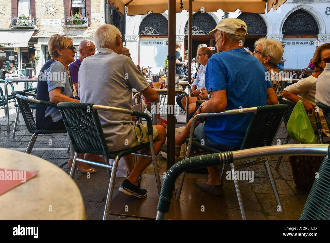 A group of retired friends having aperitif at an outdoor cafè in the sestiere of Cannaregio in summer, Venice, Veneto, Italy Stock Photo