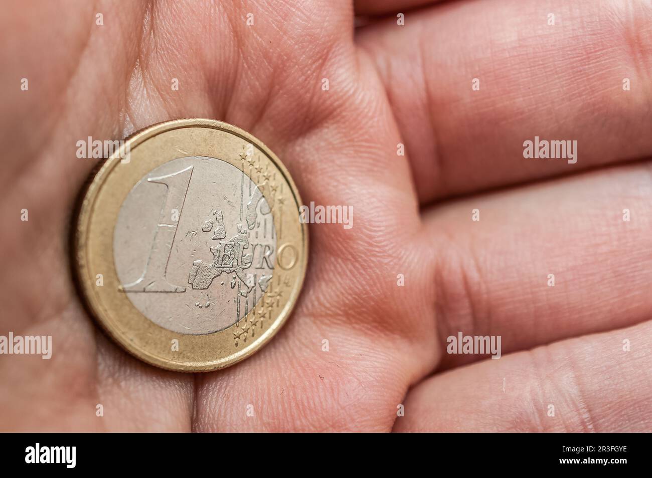 1 Euro coin held in the palm of the hand Stock Photo
