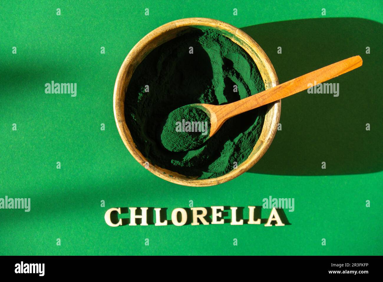 Blue-green algae with message CHLORELLA and spirulina powder in bamboo eco bowl. Super powder in spoon. Detox superfood. Natural Stock Photo