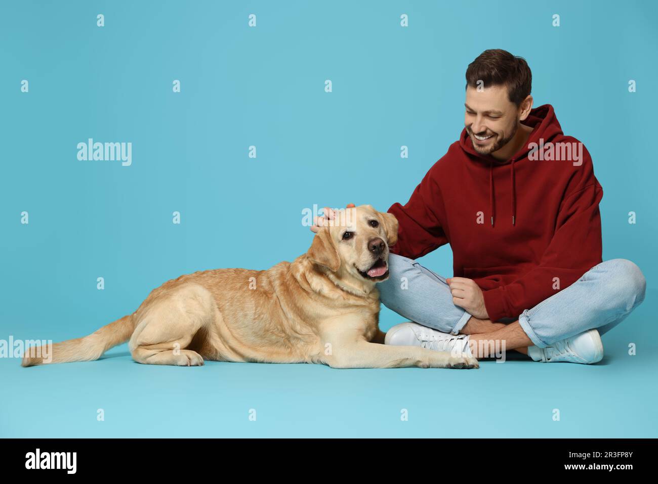 Labrador Man Happy man with his cute Labrador Retriever on turquoise background ...