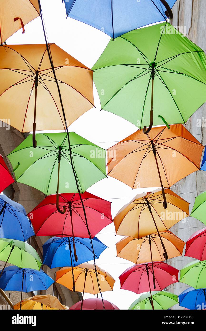 Umbrellas exhibition, street decorated. the sky is filled with colorful umbrellas. Many colorful umbrellas against the sky in ci Stock Photo