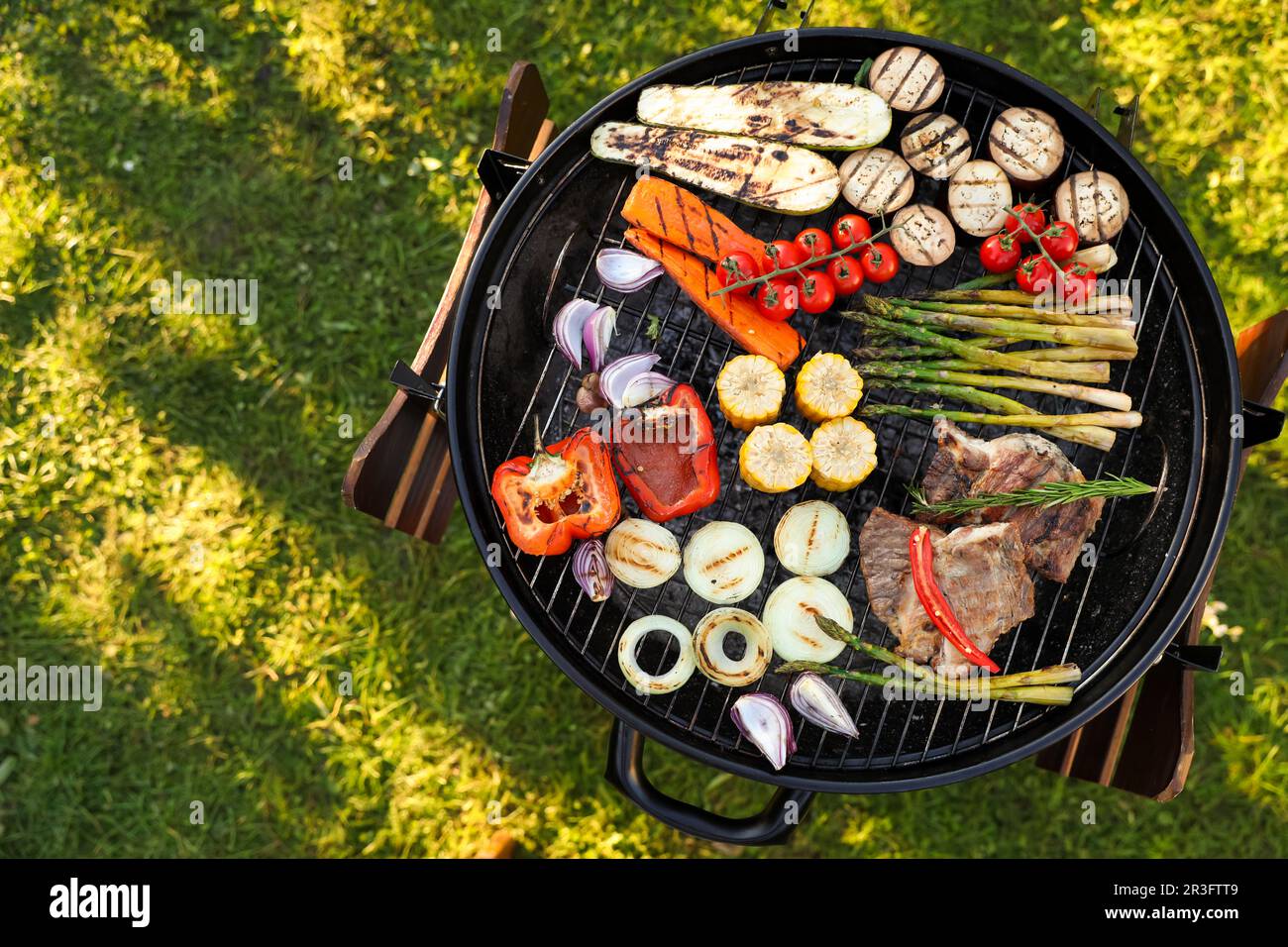 Delicious grilled vegetables and meat on barbecue grill outdoors, top ...