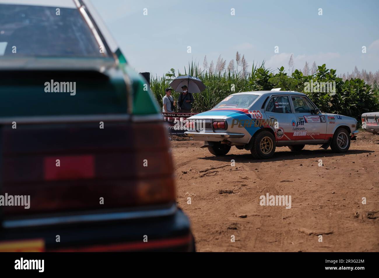 Few Corolla cars are lining up to start the rally race of Kejurnas Sprint Rally 2023 on Puslatker TNI Al Bedali Lawang, Malang with blurred foreground Stock Photo