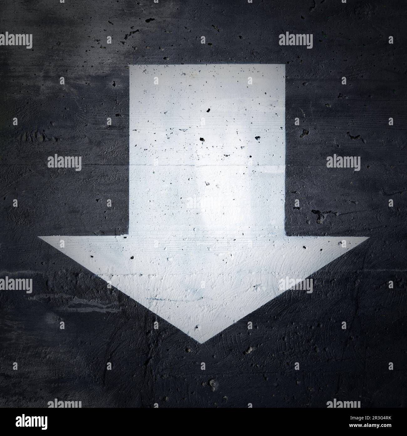 Downward pointing arrow on concrete house wall Stock Photo