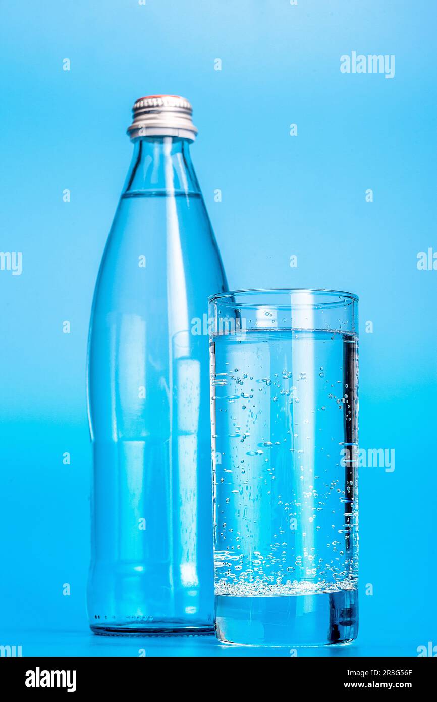 Glass water bottles on a light blue background Stock Photo Alamy