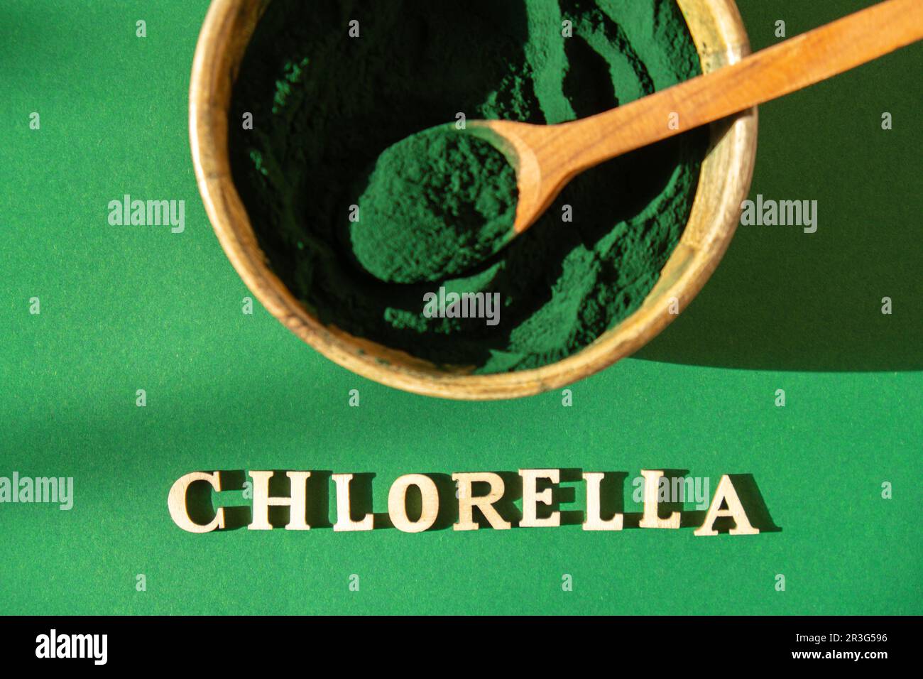 Blue-green algae with message CHLORELLA and spirulina powder in bamboo eco bowl. Super powder in spoon. Detox superfood. Natural Stock Photo