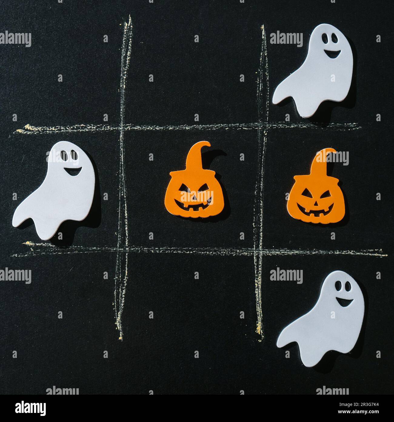 Creative tic tac toe game made of halloween decorations. Ghost bat pumpkin Autumn party concept Stock Photo