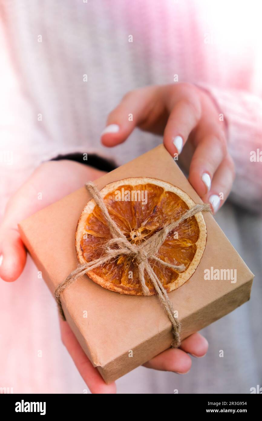 Woman giving Box with New Year's gifts, wrapped in craft paper and ...
