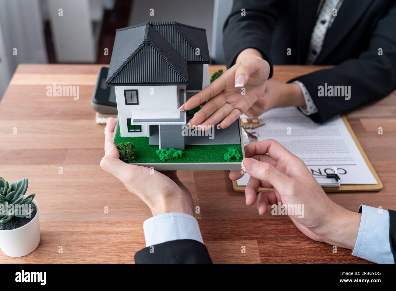 Client and real estate agent review loan contract, discussing term, interest rate, and property