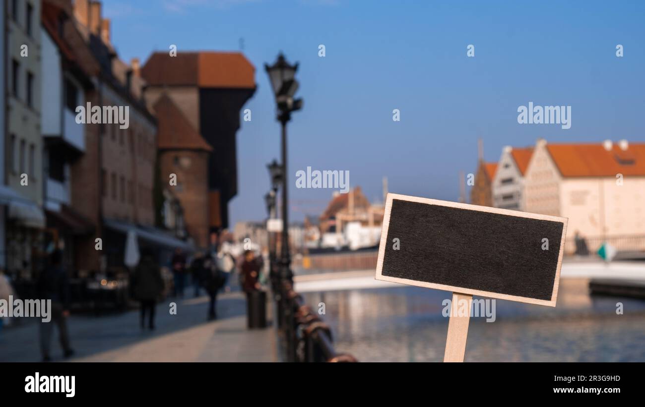 Empty mockup template Blackboard label against Gdansk beautiful old town over Motlawa river. The Zuraw Crane and colorful gothic Stock Photo