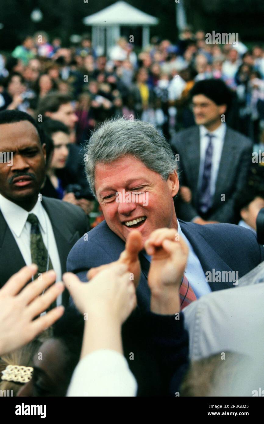 President William Clinton shakes hands durng the Clinton Administration first White House Easter Egg roll in  1993 Photograph by Dennis Brack. 88B Stock Photo