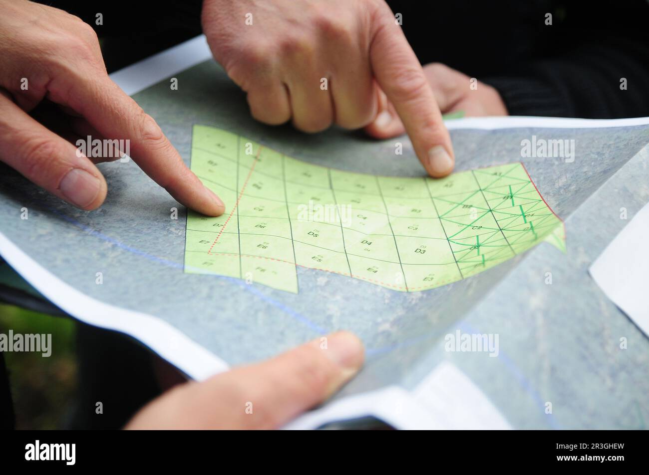 23 May 2023, Saxony-Anhalt, Tangerhütte: Employees of the Explosive Ordnance Disposal Service look at a map showing the investigation quadrants in a patch of forest near Tangerhütte. Thirty years after the fall of the Berlin Wall and almost 80 years after the end of World War II, munitions and unexploded ordnance still lie in the forests, especially in eastern Germany. Photo: Simon Kremer/dpa Stock Photo