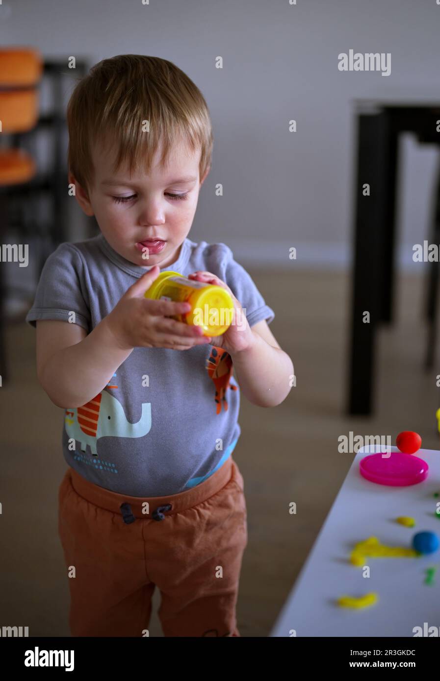 Portrait of little toddler playing at the table Stock Photo