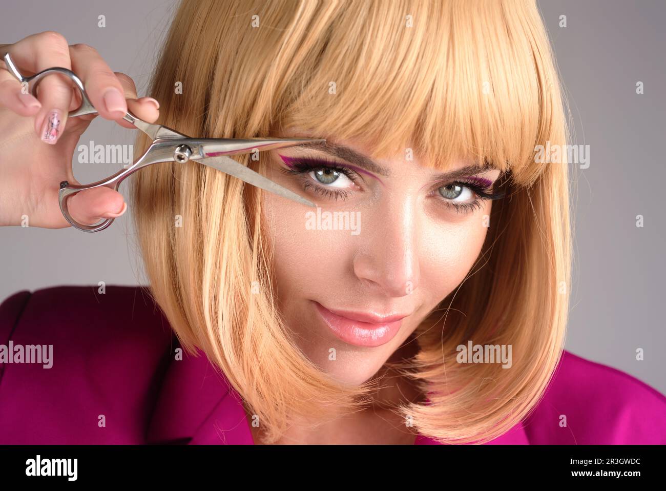 Haircut. Portrait of young woman hairdresser cutting hair with scissors