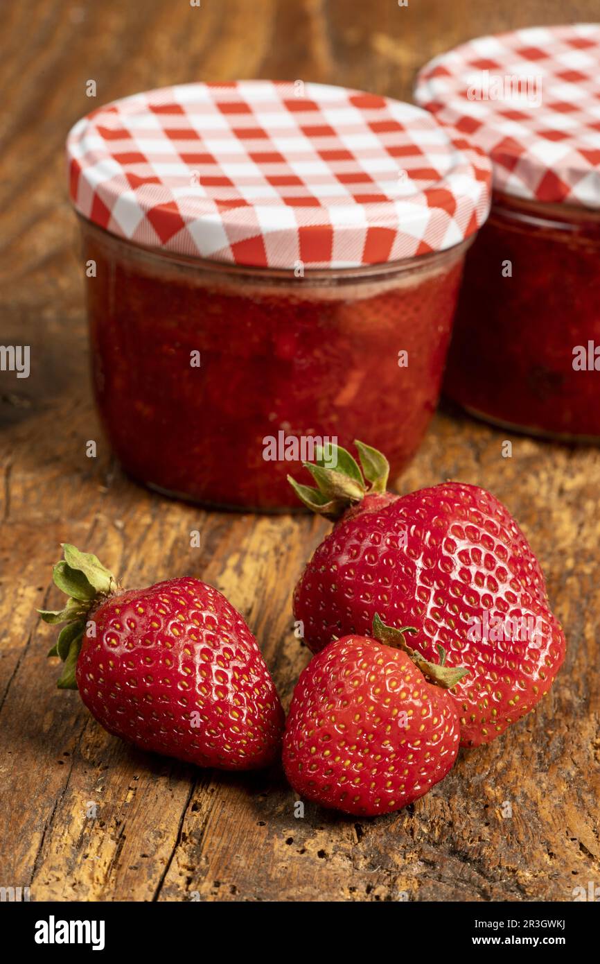 Strawberry jam on dark wood Stock Photo