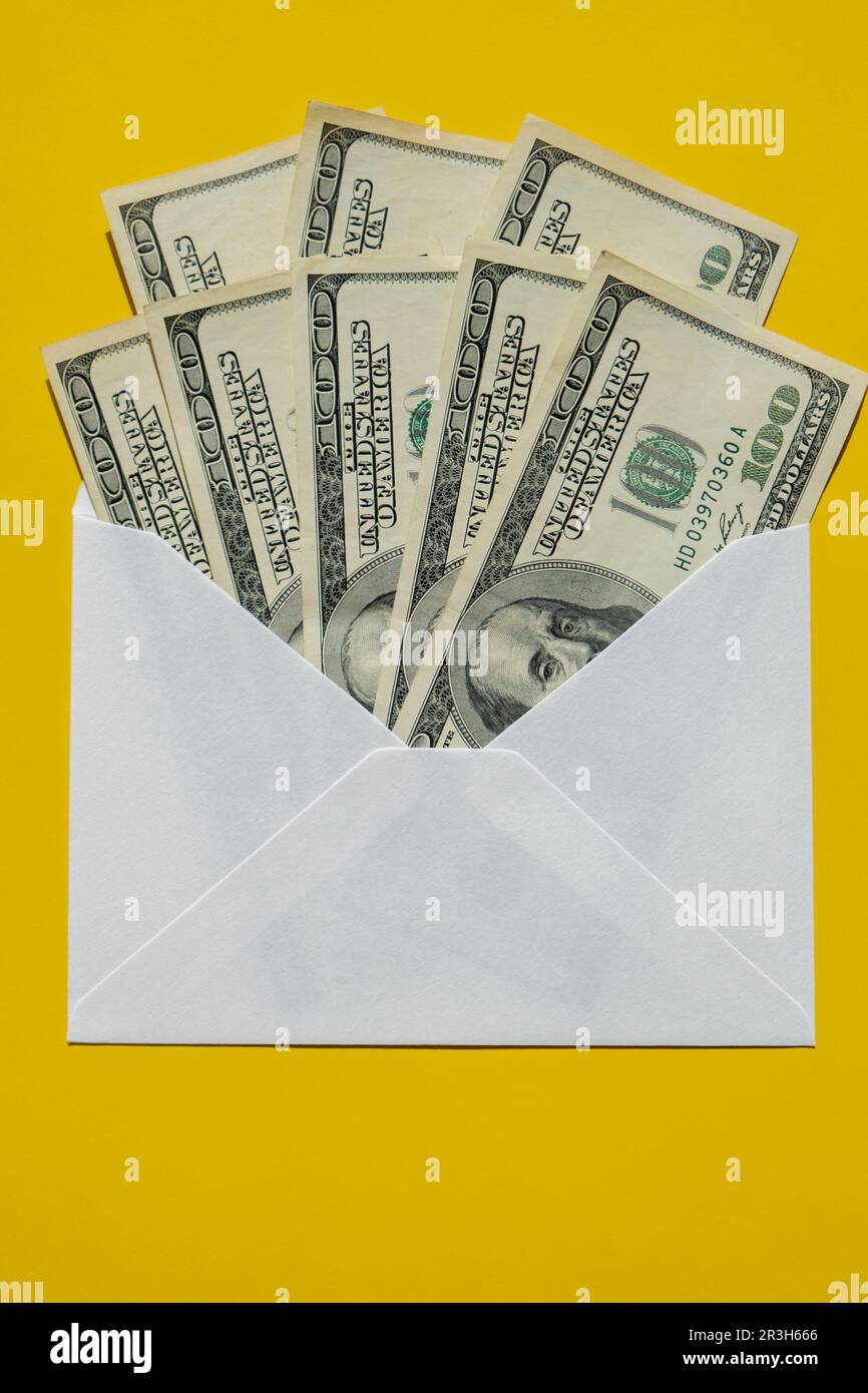 Dollar banknote saving money in envelope on yellow background copy space. Consumption and economy Collecting money. Tips. Busine Stock Photo
