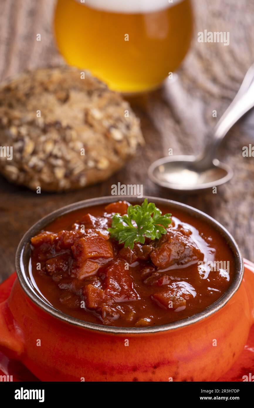 Goulash on dark wood with beer Stock Photo