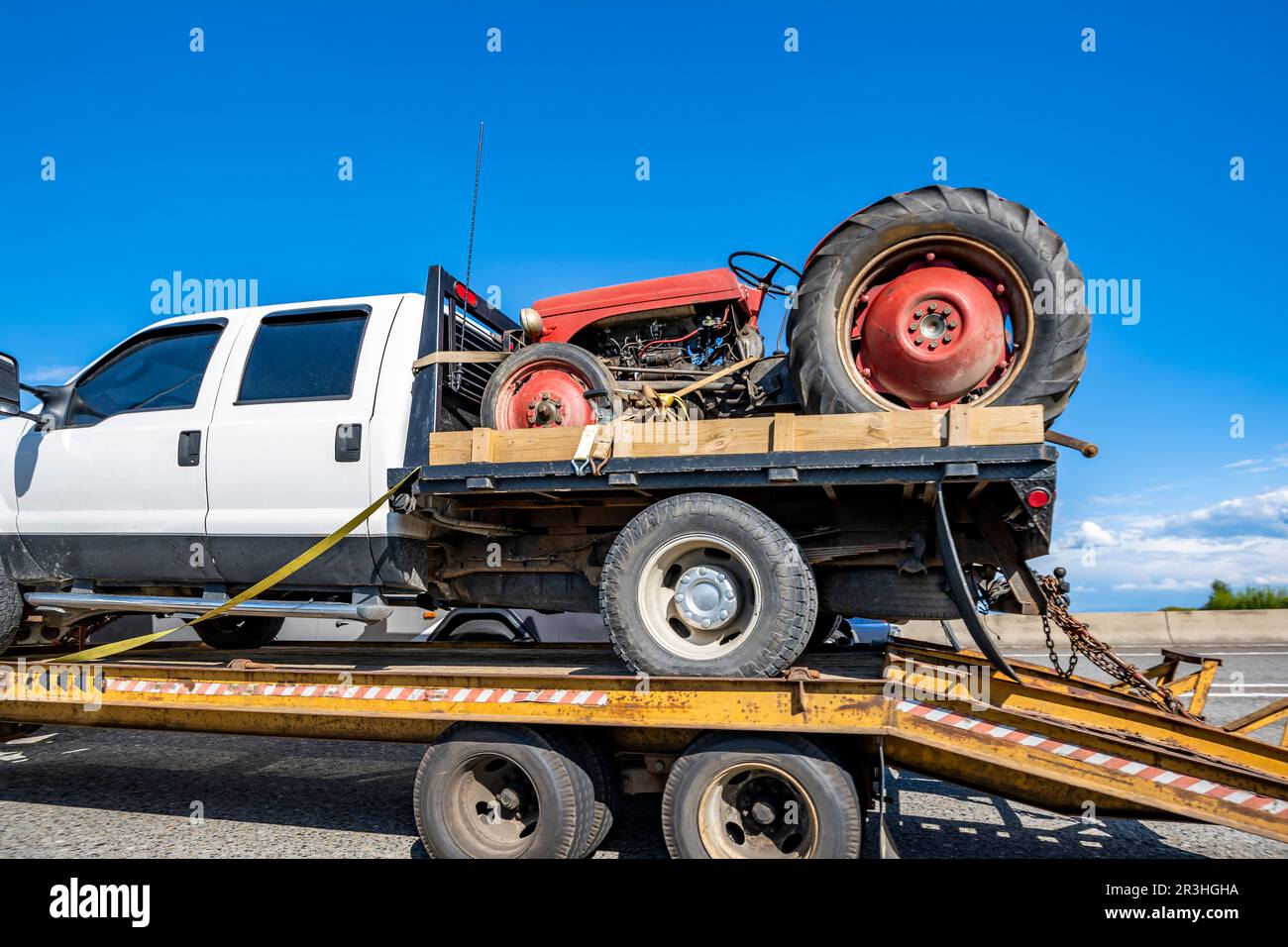 Big rig tow semi truck transports on the step down semi trailer small