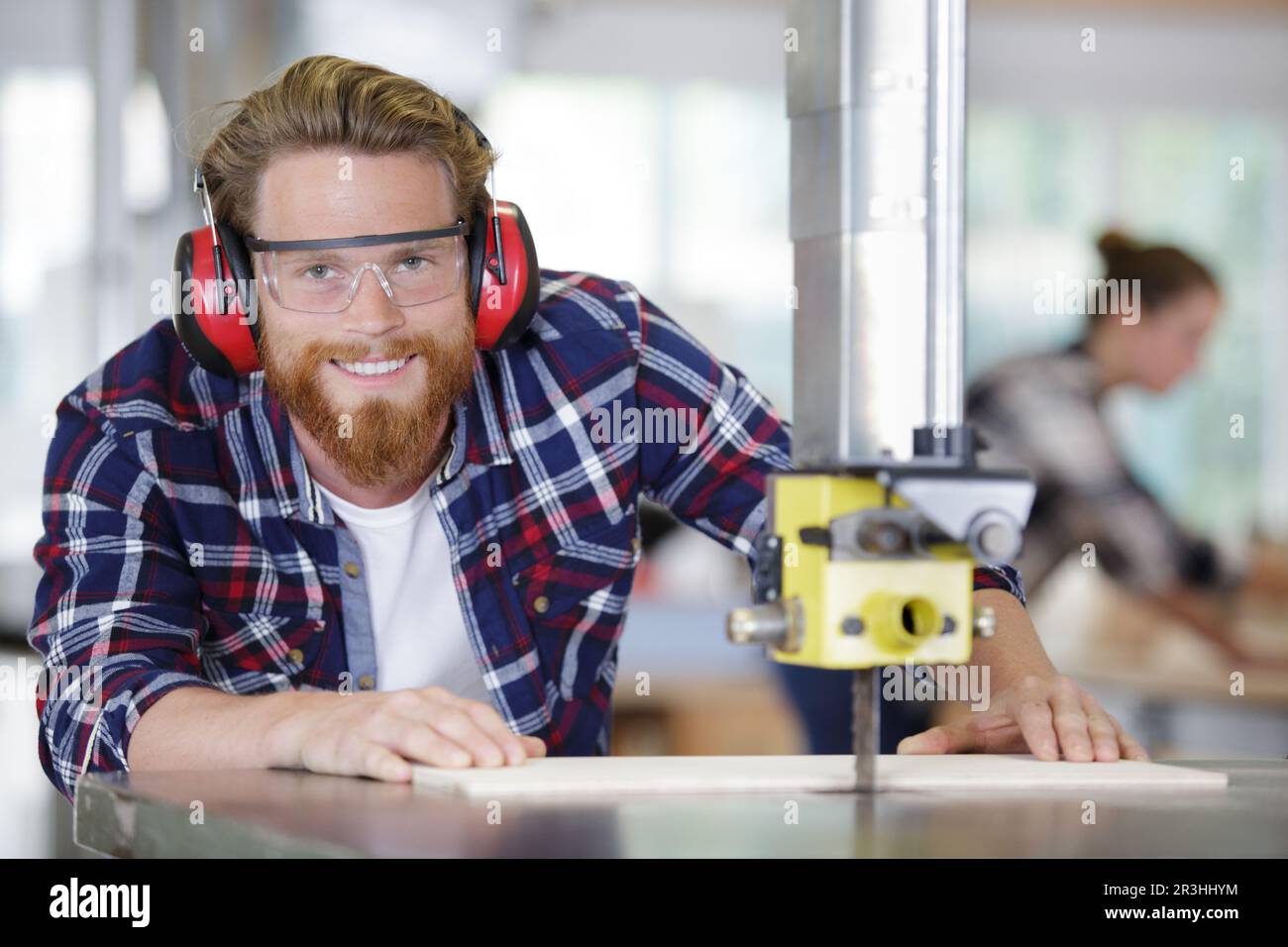 smiling joiner using drilling machine to make drawer at workshop Stock Photo