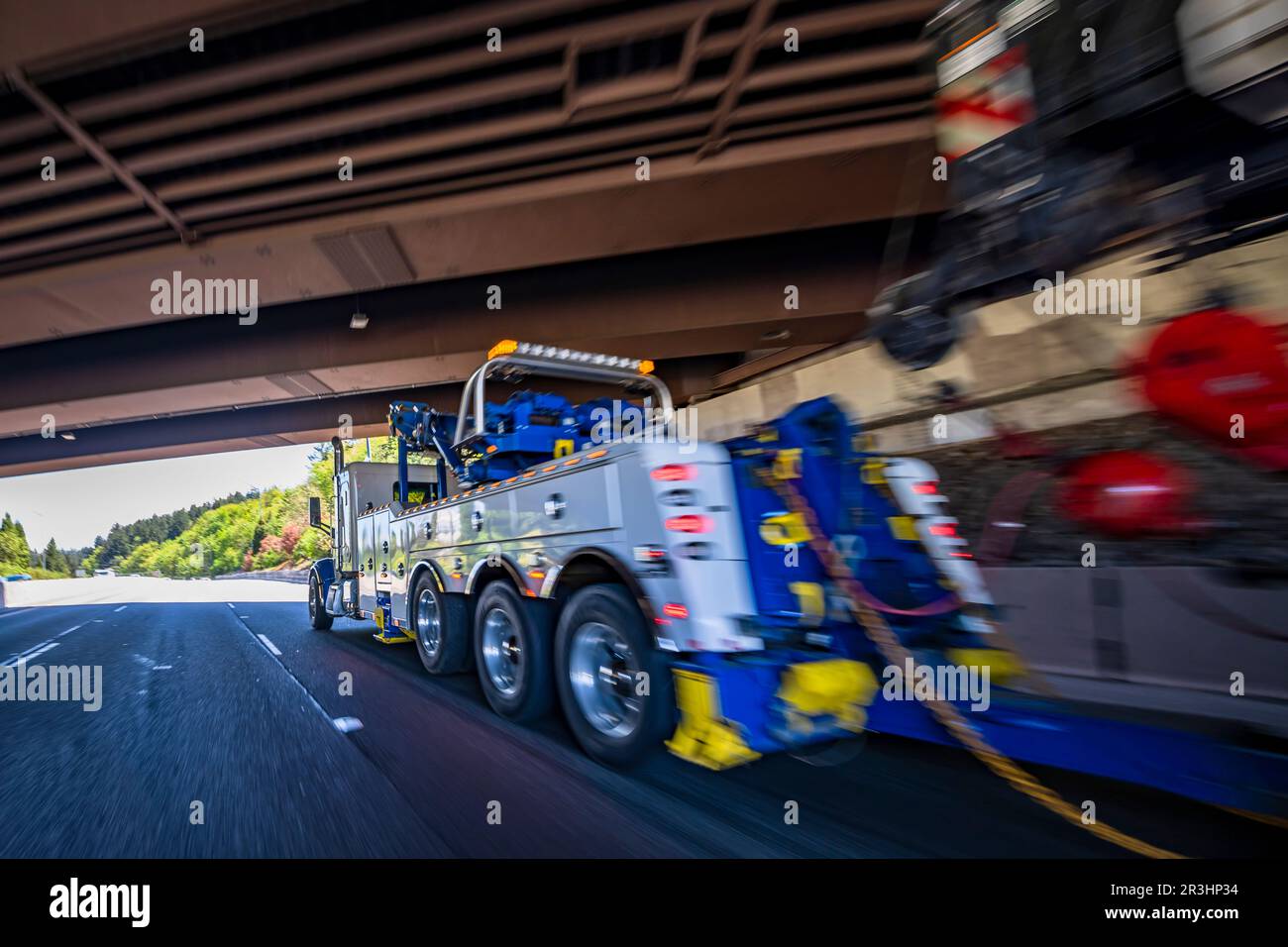 Powerful blue big rig heavy duty towing semi truck tractor with lifting