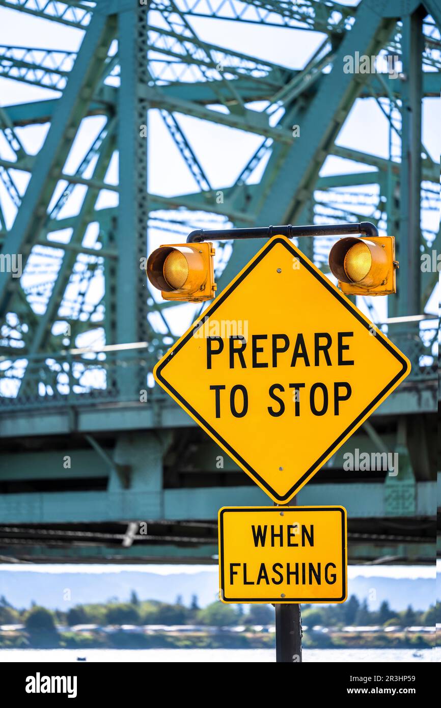 Attention to drivers traffic flash light warning signal with traffic sign prepare to stop on the access road to the truss Interstate Columbia River Dr Stock Photo