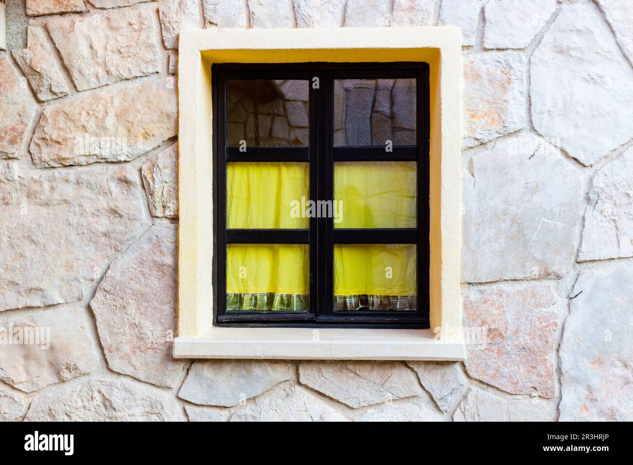 Black framed window on stone wall Stock Photo