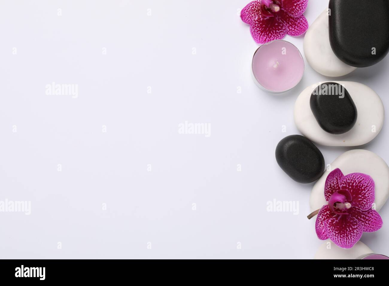 Flat lay composition with spa stones and flowers on white background ...