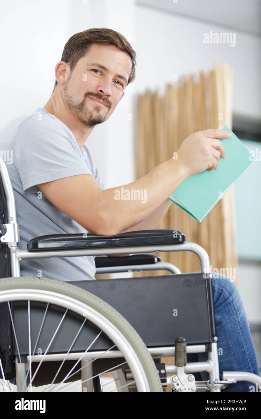 disabled man in wheelchair reading a book Stock Photo Alamy