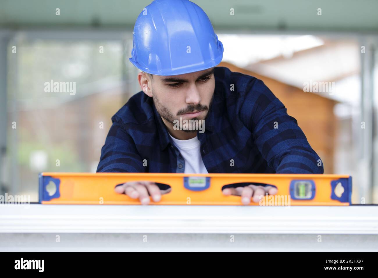 tradesman using a bubble level on a wall Stock Photo