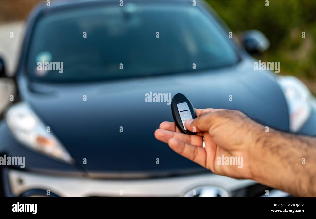 Holding a car remote with lock and unlock buttons. selective focus with blurred background Stock Photo