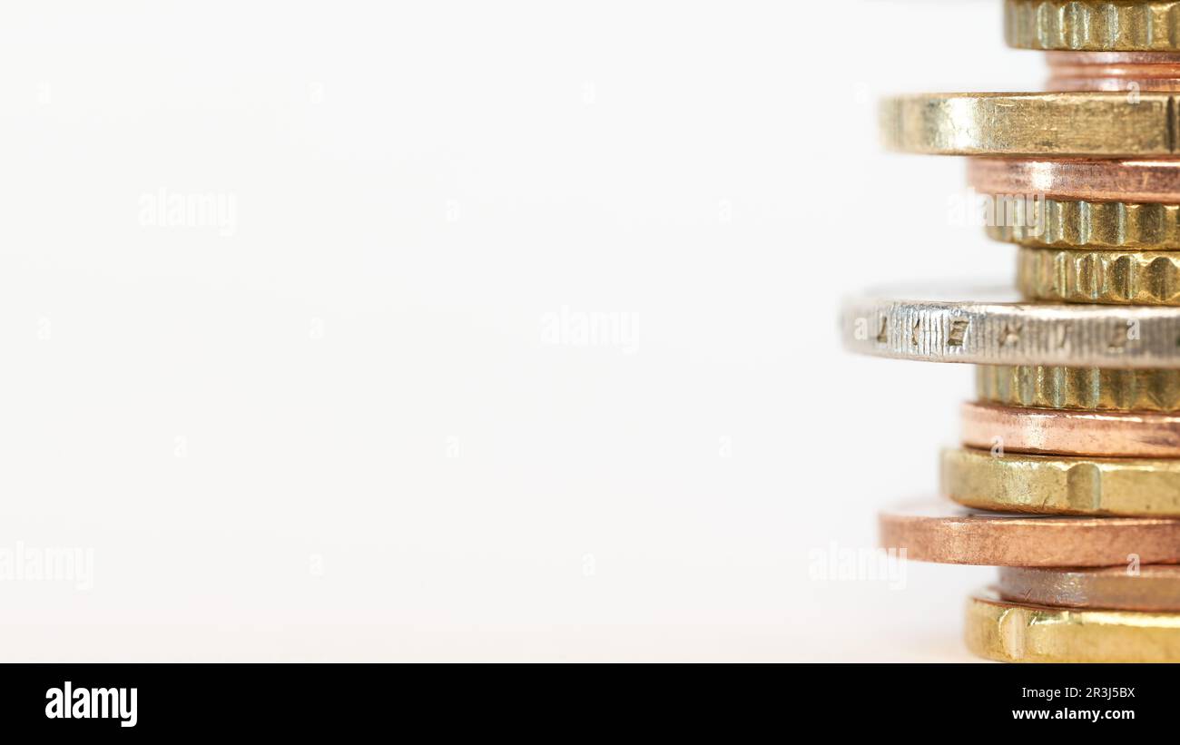 Piled up euro coins on table with white background and copy space on