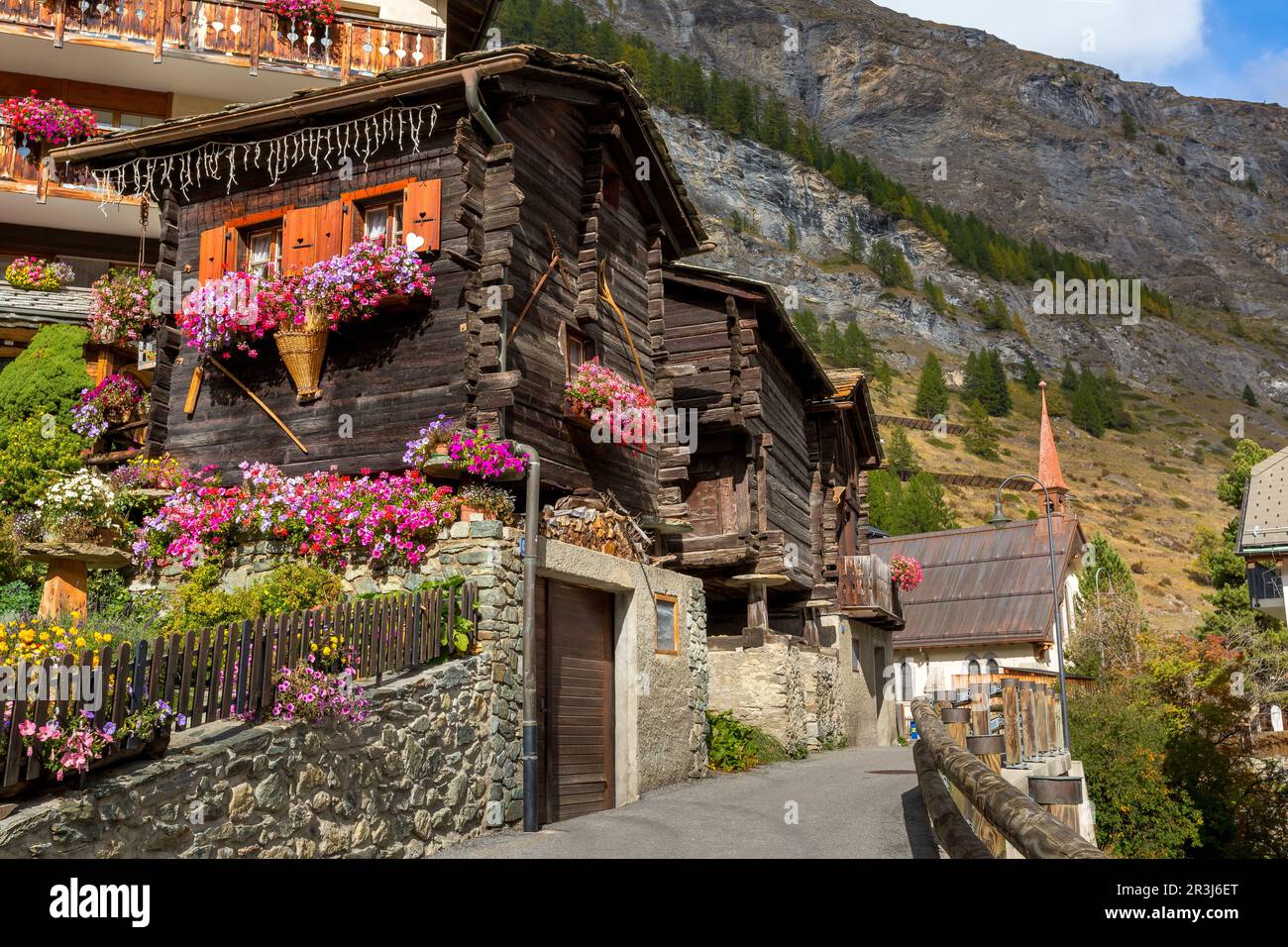 Traditional wooden alpine chalet with geranium flowers on the window in summer, Zermatt alpine village, Switzerland, Swiss Alps Stock Photo