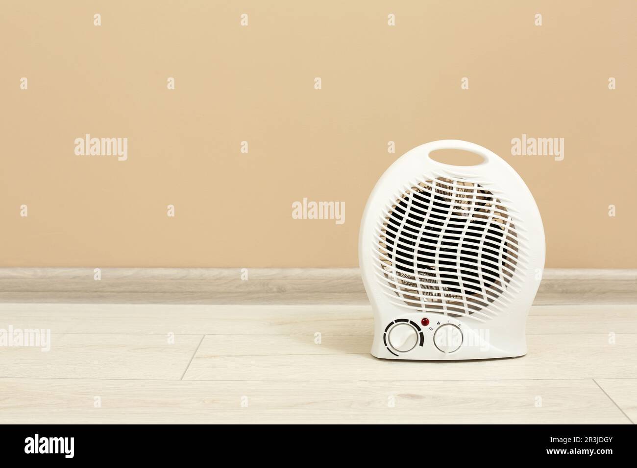 Modern electric fan heater on floor near beige wall, space for text Stock  Photo - Alamy