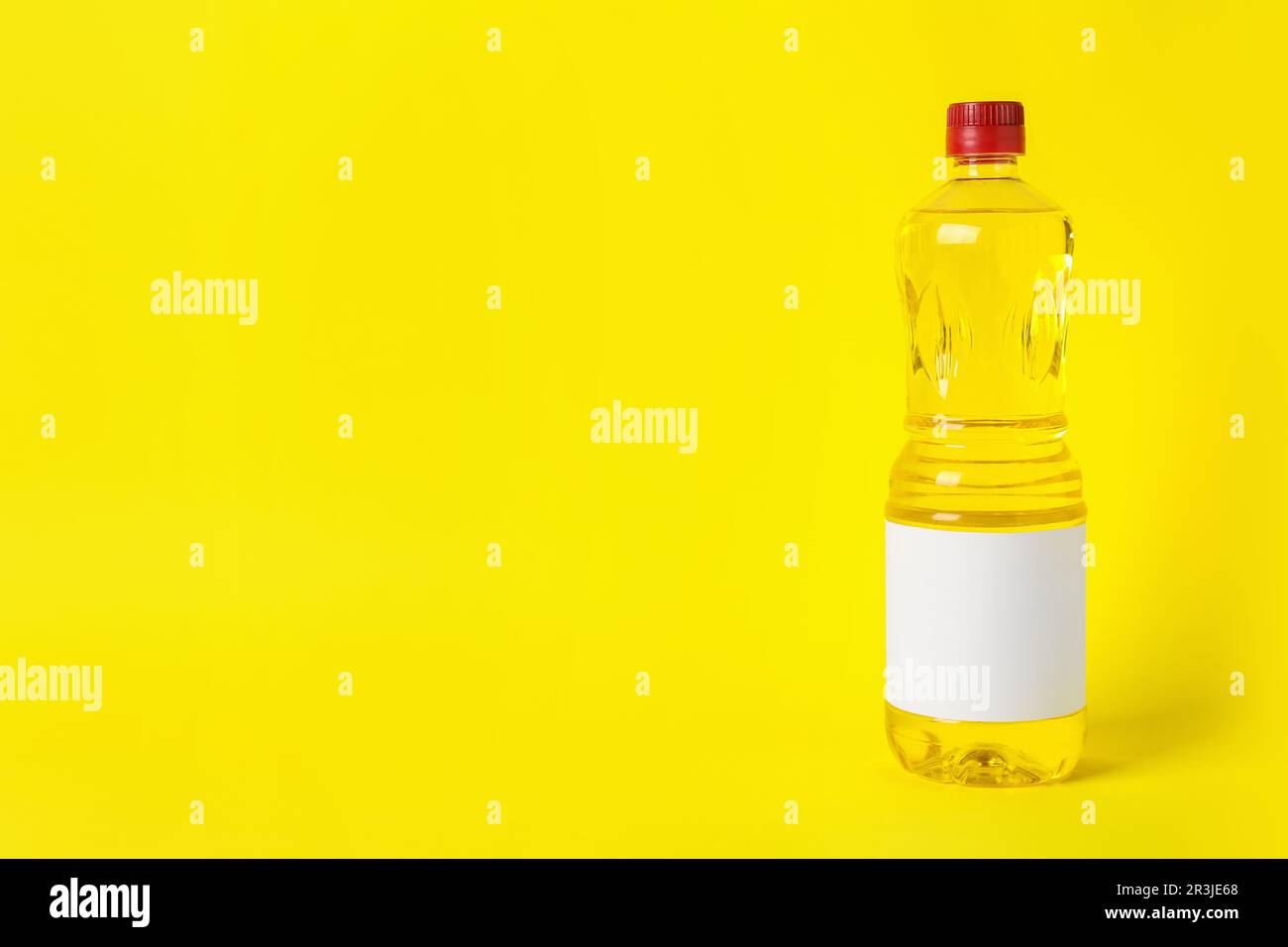 Bottle of cooking oil on yellow background. Space for text Stock Photo ...