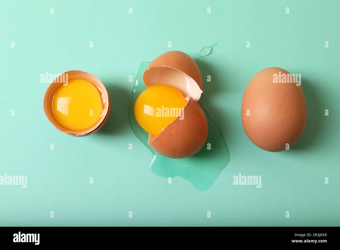 Cracked and whole chicken eggs on turquoise background, flat lay Stock ...