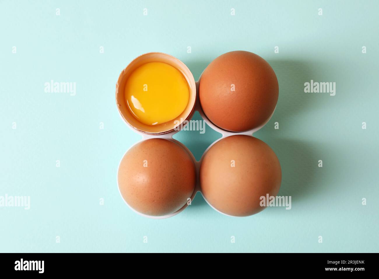 Cracked and whole chicken eggs on light blue background, flat lay Stock ...