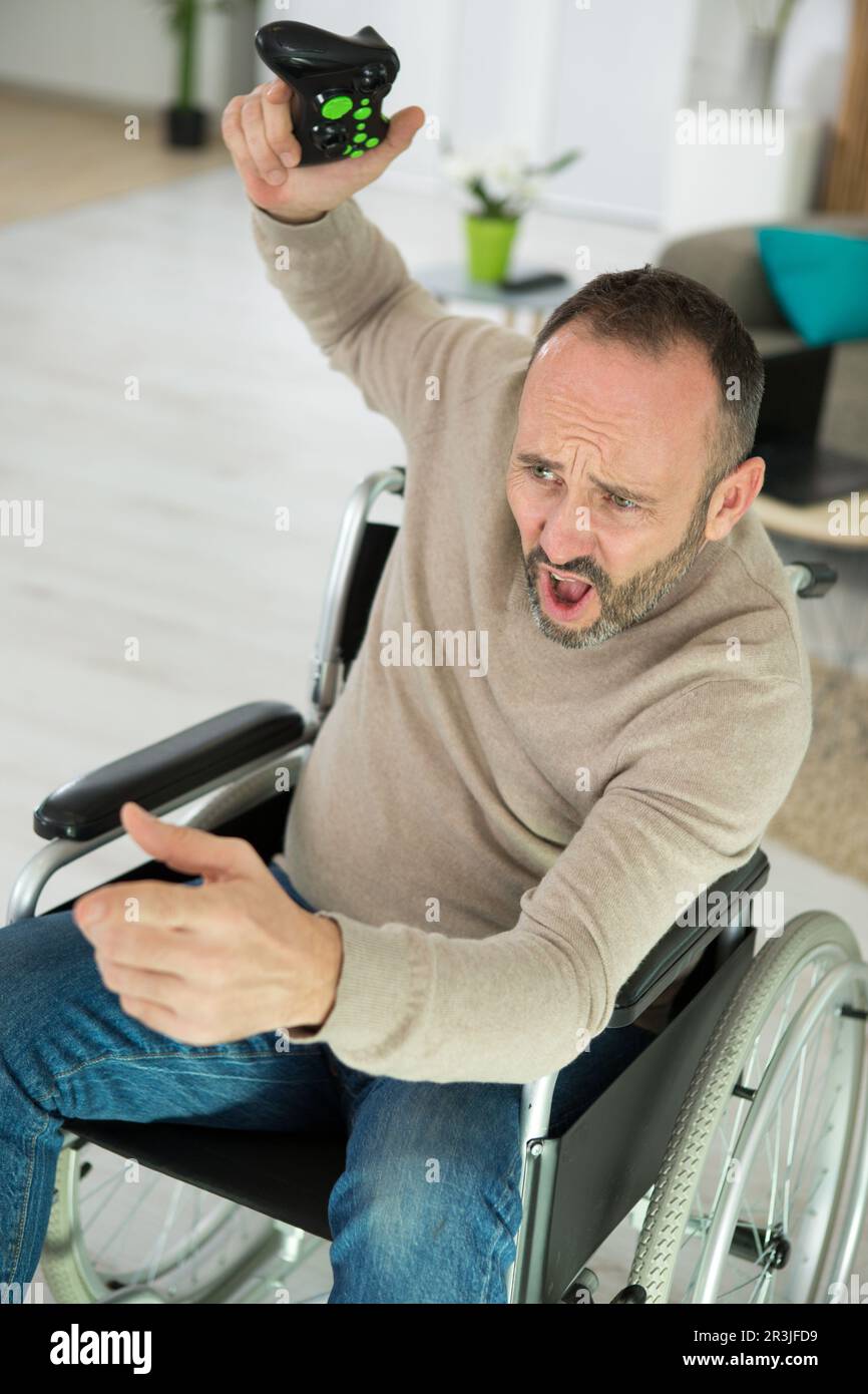 disabled man playing computer games during rehabilitation Stock Photo