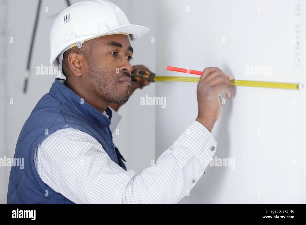 man measuring a wall using a folding ruler Stock Photo