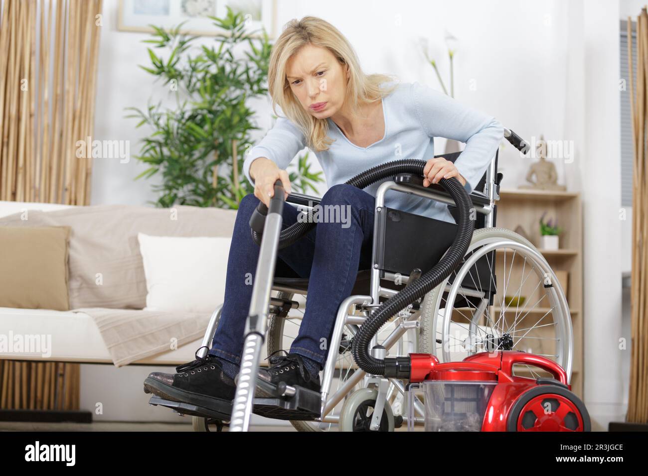 senior woman in wheelchair vacuuming a carpet Stock Photo Alamy