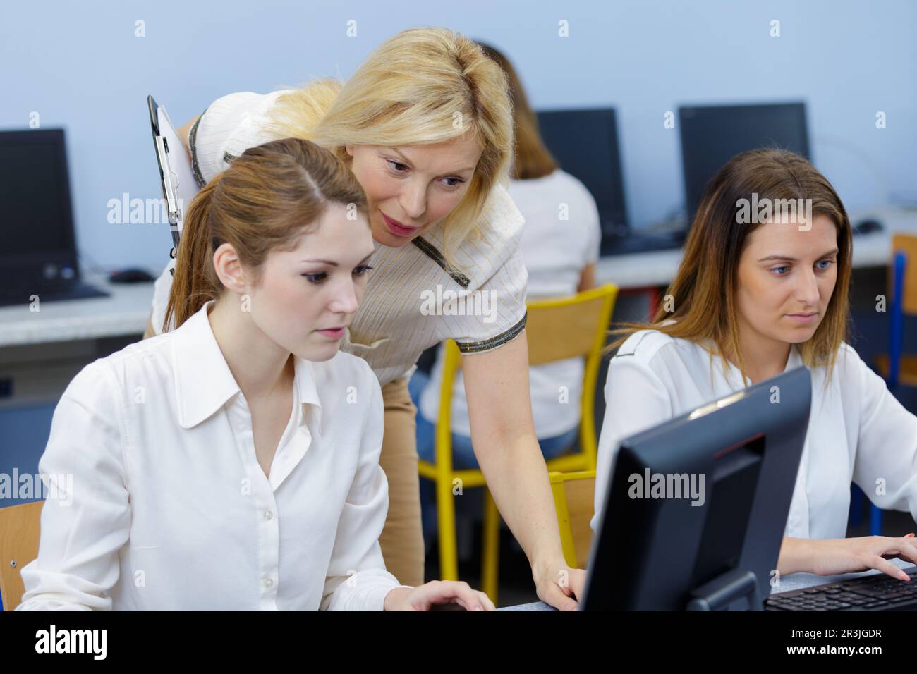 teacher guiding teenage lady using computers Stock Photo - Alamy