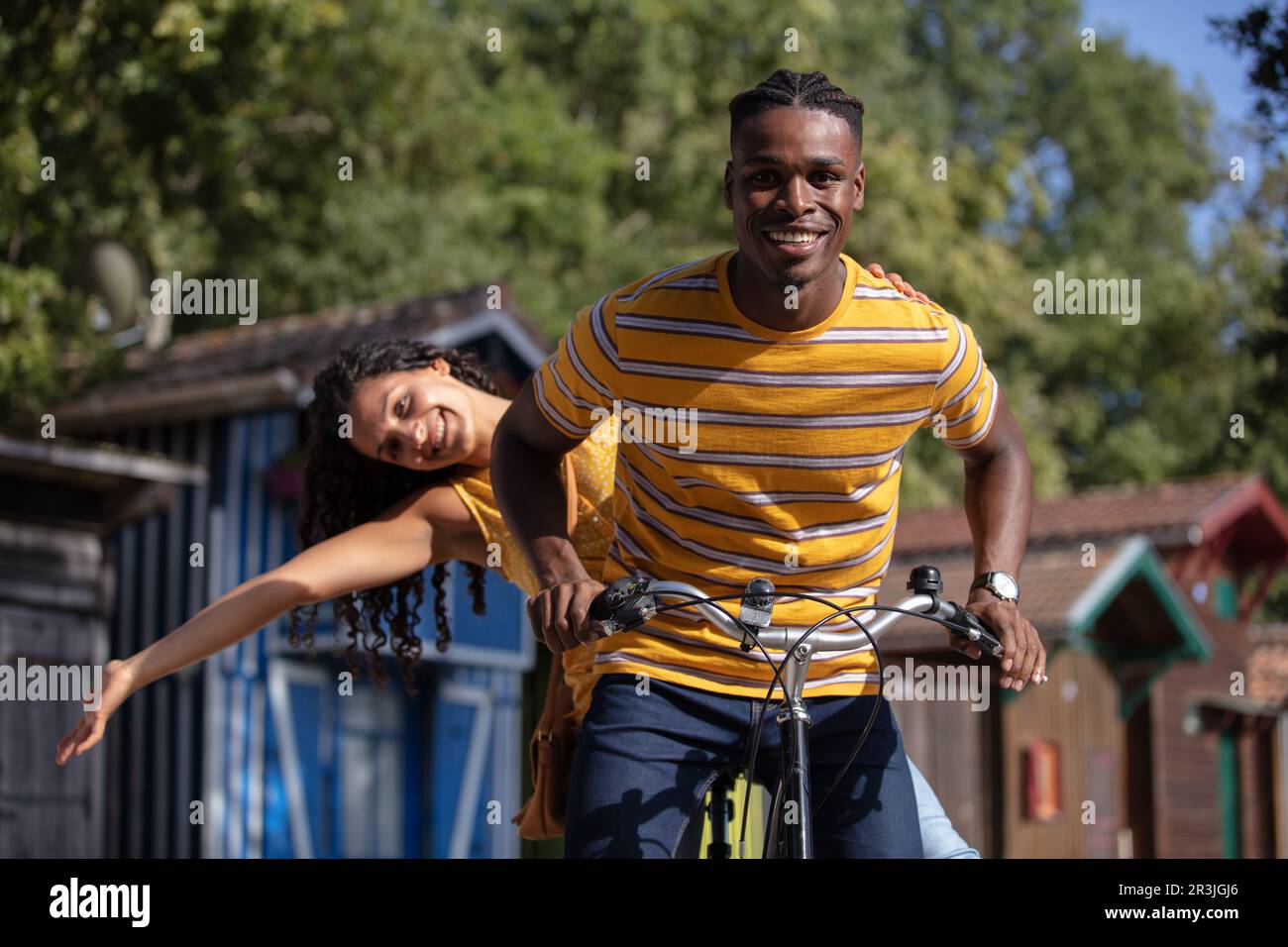 Mixed Riding portrait of a mixed race couple riding on tandem bicycle Stock Photo ...