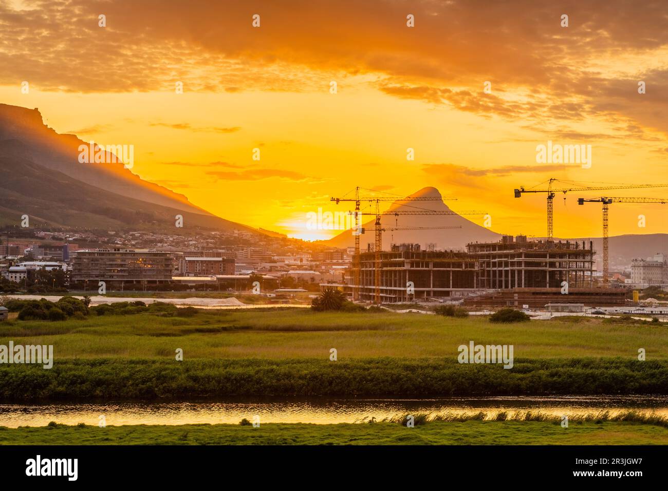 Construction cranes on building site at sunset in Cape Town Stock Photo