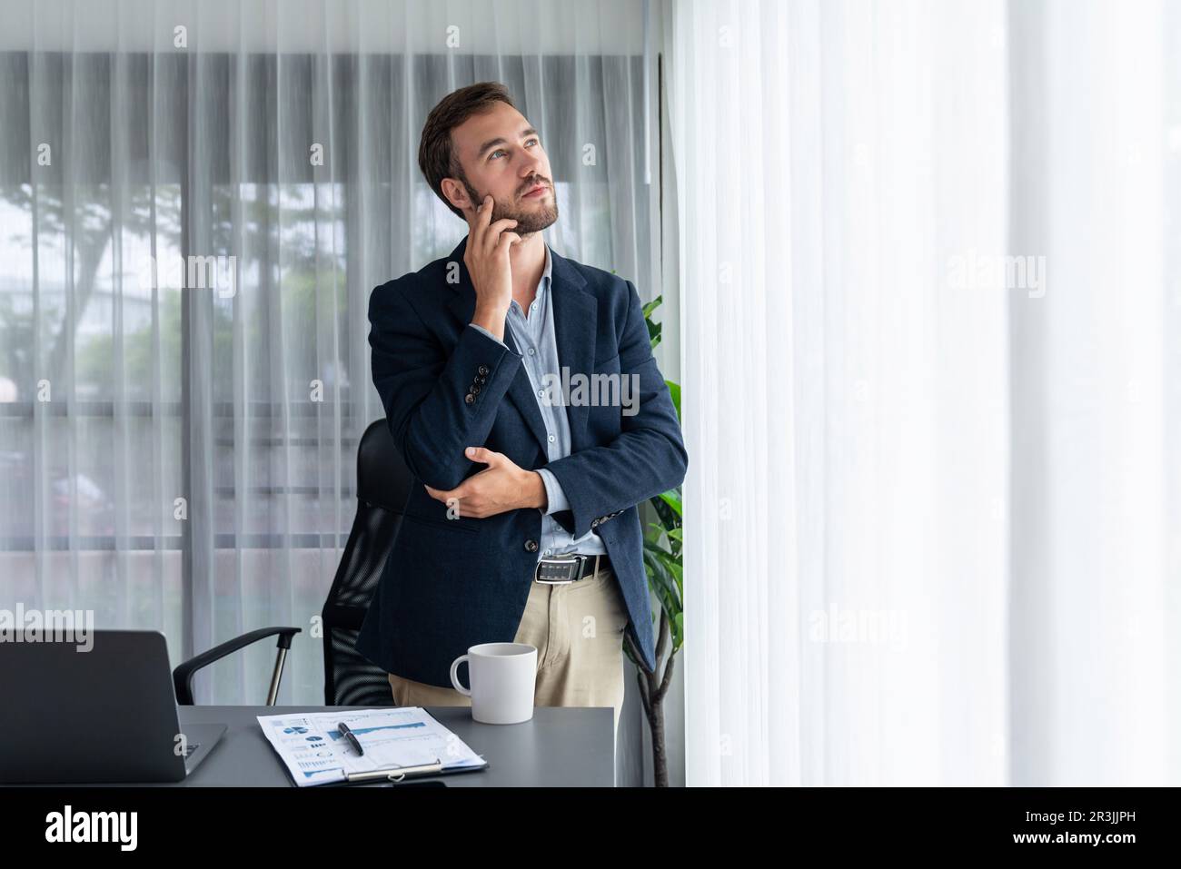 Handsome businessman in black suit stand confidently in his modern