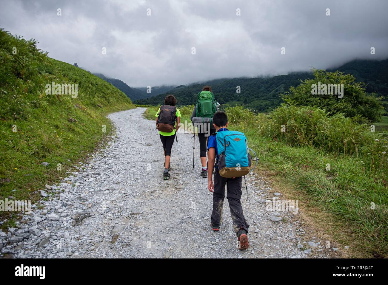 mujer con dos niños andando en la pista de Anapia a prados de Sanchese, trekking de las Golondrinas, Lescun, región de Aquitania, departamento de Pirineos Atlánticos, Francia. Stock Photo