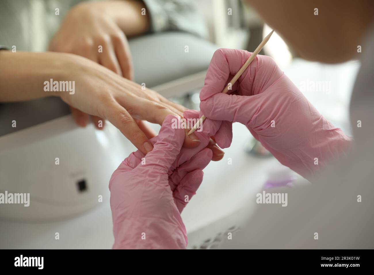 Professional manicurist working with client in beauty salon, closeup ...