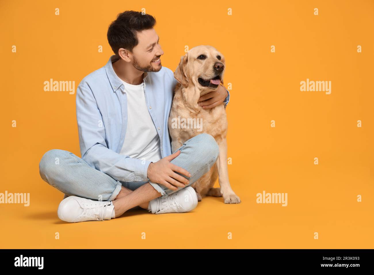 Labrador Man Happy man with his cute Labrador Retriever on yellow background. Space ...