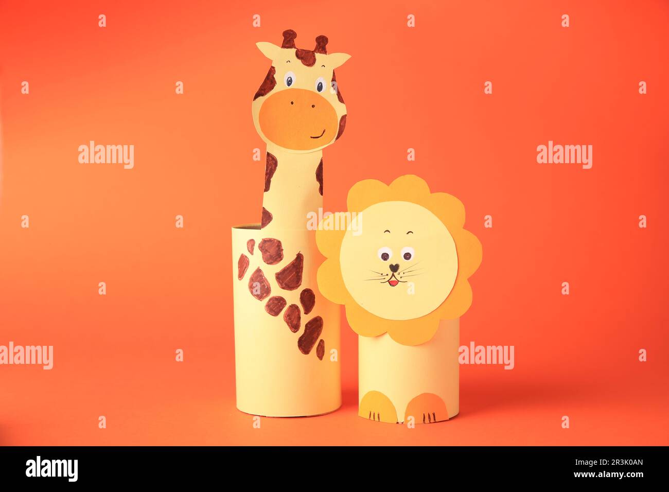 Toy giraffe and lion made from toilet paper hubs on orange background. Children's handmade ideas Stock Photo