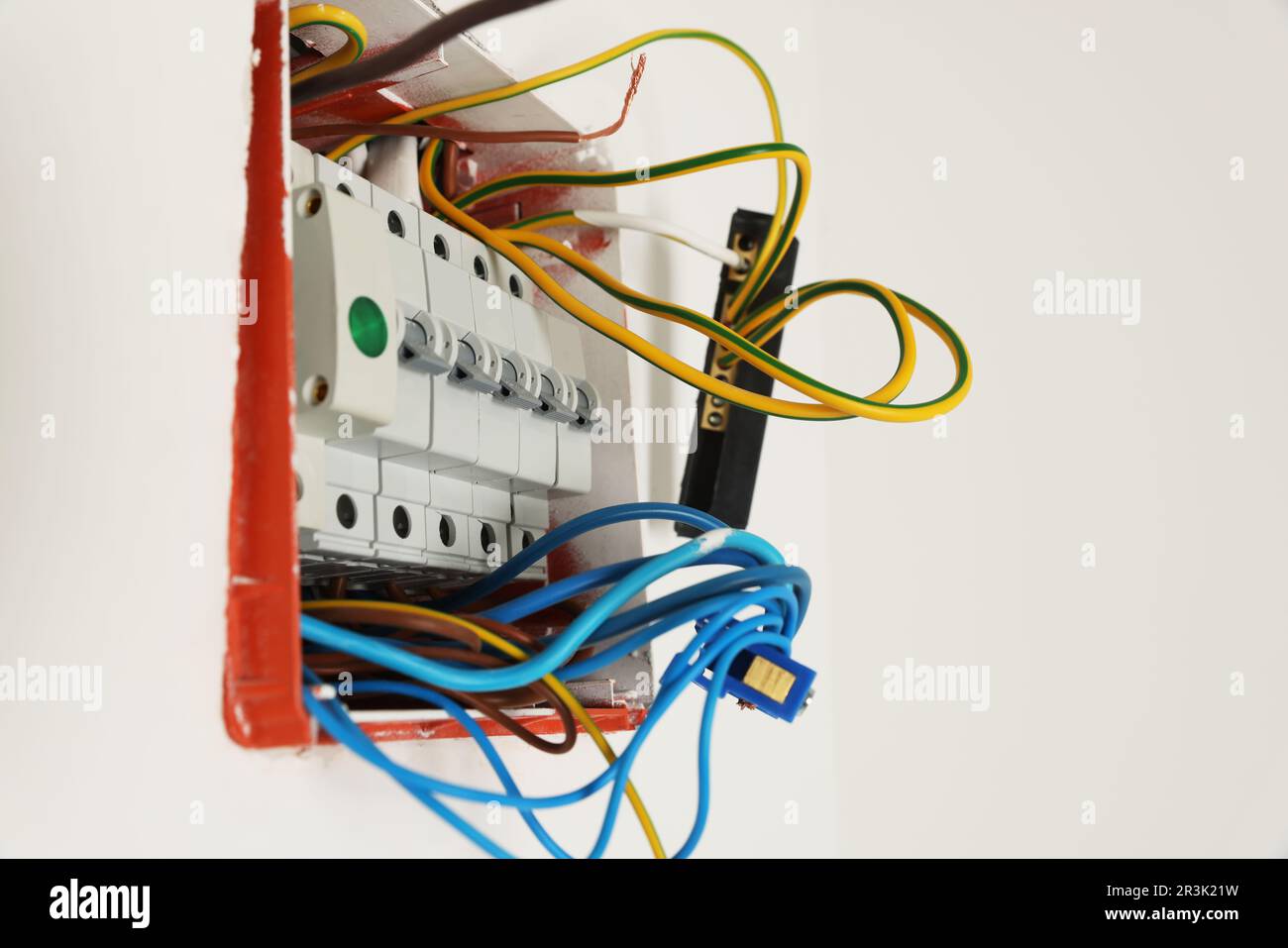 Switchboard with different cables on white wall. Installation of