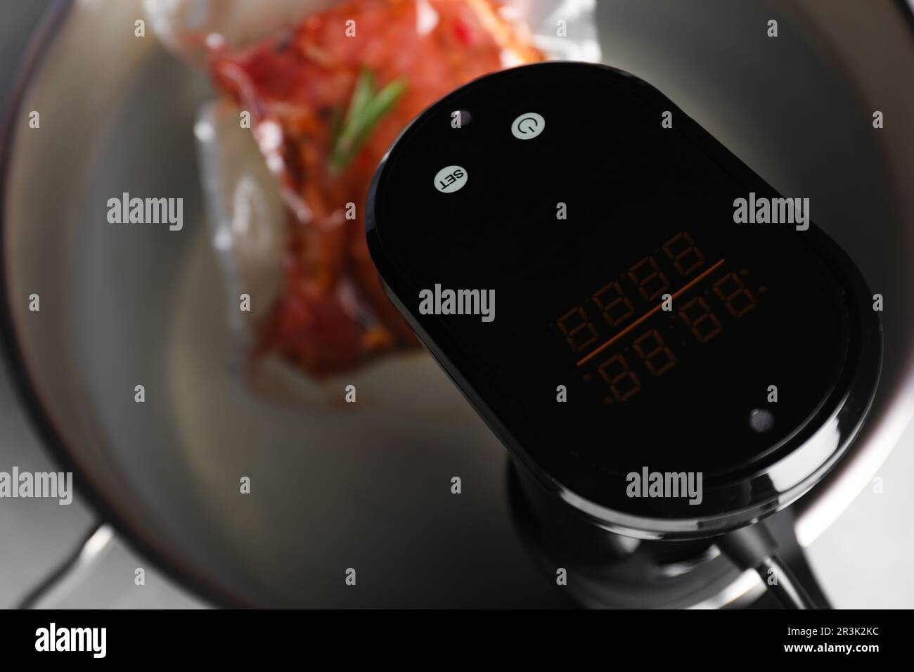 Thermal immersion circulator and vacuum packing with meat in pot on table, closeup. Sous vide