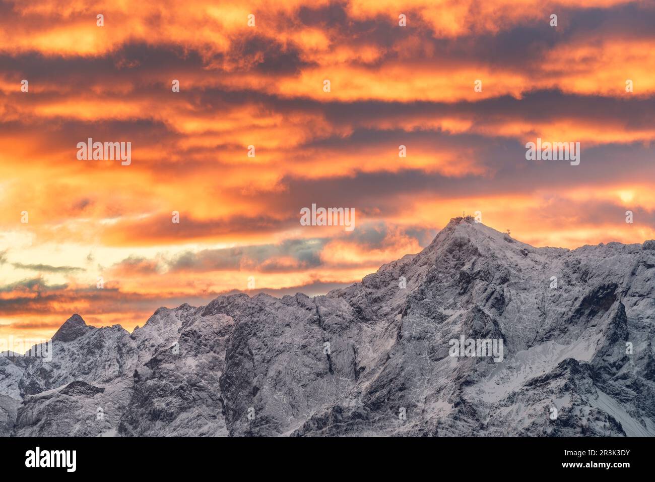 Mountain Zugspitze at sunrise with colorful clouds, highest mountain in germany Stock Photo
